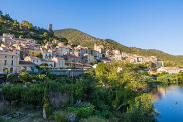 Fototapeta na wymiar Vue en fin de journée du village médiéval de Roquebrun au bord de l'Orb dans le Parc naturel régional du Haut-Languedoc