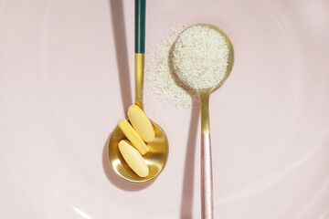 Collagen powder and pills in spoon. Concept of nutritional supplement for skin beauty