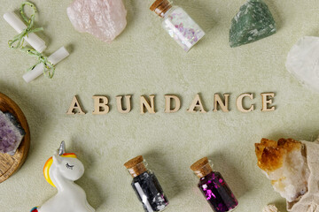 Abundance word wooden letters with magic and happy objects, crystal stones.
