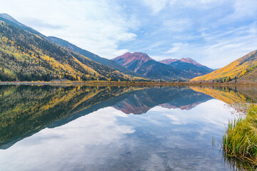 Reflection of autumn aspen trees along Crystal Lake along Red Mountain pass in the San Juan...