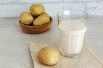 A transparent glass with potato milk on the table. A new trend in eating healthy. Alternative food concept. Vegetable Milk for Vegans. Horizontal orientation.