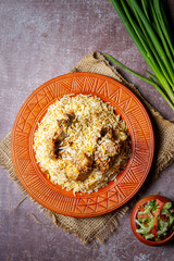 Fried rice with chicken prepared and served in a wok of natural wood in the background top view