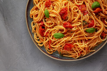 Homemade Spaghetti Pasta with Fresh Tomato Sauce on a Plate on a gray background, top view. Flat...