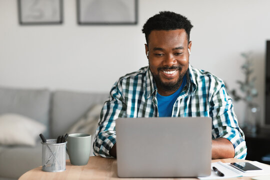 Cheerful Black Man Using Laptop Working Distantly Online At Home