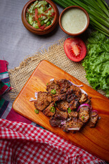 Barbecue chicken wings close up on wooden tray, shot with selective focus