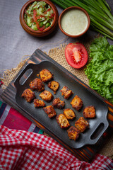 Barbecue chicken wings close up on wooden tray, shot with selective focus