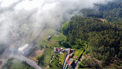 Vista de drone sobre campos no meio de neblina 