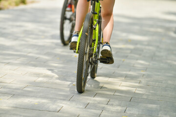 selective focus. cyclist on a bicycle leg and wheel close-up. Back view. A walk on the bike. the female rides a bicycle. Cyclist pedaling on a bicycle. High quality photo