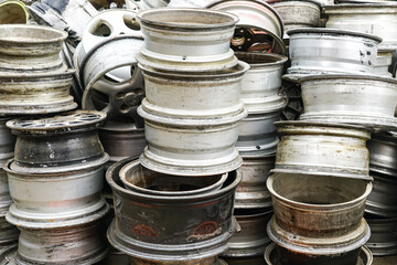 Many used passenger car alloy wheels at recycling scrap yard