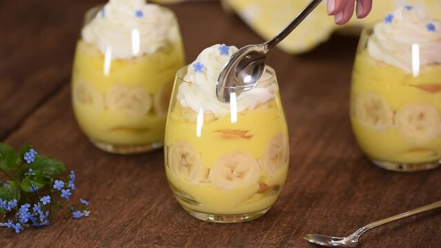 Glass with delicious banana pudding on table