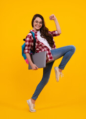 Fototapeta na wymiar Back to school. Teenager schoolgirl hold notebook laptop. School children on isolated yellow studio background. Run and jump, jumping kid.