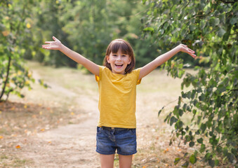 Jong kind armen opgewekt naar de hemel, vrijheid vieren. Positieve kinderen emoties. Gratis lachend meisje in zomer bos genieten van de natuur. Gelukkig leven concept