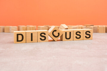 word discuss made with wood blocks. text is written in black letters, light background