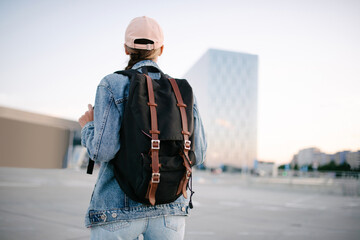Tourist girl with her backpack looking at city landscape, back view Adventure and travel in the concept . Backpack rear view. Tourism in city. - 518193413
