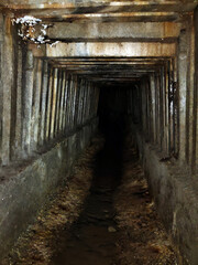 The tunnel of the underground sewage collector with ribbed walls going into perspective