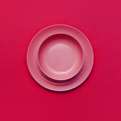 Round red plate on a bright red background.