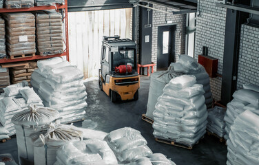 Forklift in warehouse with grain bags for export. Distribution and logistics concept.