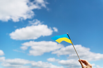 Pray for Ukraine. Ukrainian national yellow-blue flag against a beautiful sky. Independence Day 24 August.