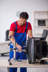 Young male repairman working at workshop