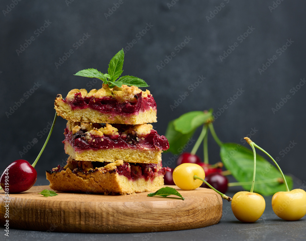 Poster square slices of cherry crumble lie in a stack on a black background