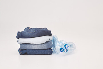 second-hand clothing or recycling, ecology concept, jeans, t-shirt, pants are gathered in a pack on a white floor