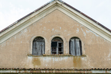 An old brick non-residential building. An ancient historical building. Unusual arched windows and large wooden gates in an ancient synagogue.