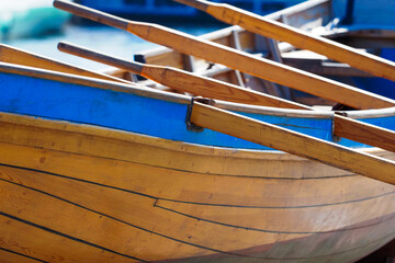 Multi-oared wooden boat moored to the sea pier