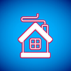 White Merry Christmas house icon isolated on blue background. Home symbol. Vector