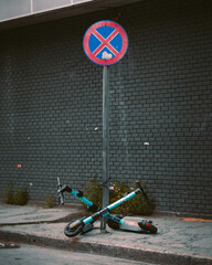 An stop sign with two scooters parked next to it.