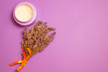 Obraz na płótnie Canvas Purple jar lavender cream dry on purple background. View from above. Space copy.
