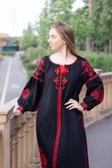 portrait of young woman wearing black and red vyshyvanka. national embroidered Ukrainian shirt. girl in dress outdoors in park. summer