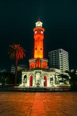 Fototapeta na wymiar Night shot of Izmir watch tower with beautiful red and orange lighting on the tower.