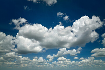 White puffy cumulus clouds on summer blue sky