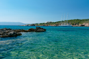Fototapeta premium Amazing shot of a sea coast with clear blue water and stones in the foreground.