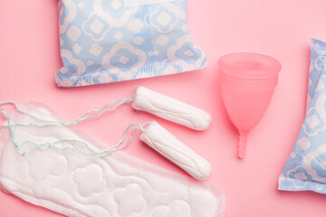 Woman menstruation cycle, sanitary pads, menstrual cup anв tampons on pink, intimate hygiene  set 