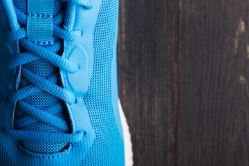 Macro photography of sneakers made of blue mesh fabric with lacing. Laced closure of a new sports...