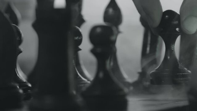 Chess pieces placed on the chessboard. Black and white video of chess game