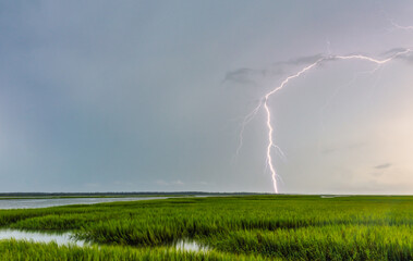 Fototapeta premium Lightning over low country marshes