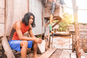 Long haired indigenous teenager sitting in a cabin on the coast of the pacific sea in Bluefields...