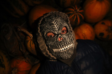 Defocus Halloween people. Person in grim reaper mask standing on black background and lying on...