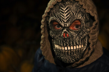 Defocus closeup Halloween people portrait. Person in grim reaper mask standing on black background....
