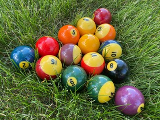 Billiard balls for American billiards on the grass. Pool balls. Billiard snooker pyramid. Colored pool or billiard balls.