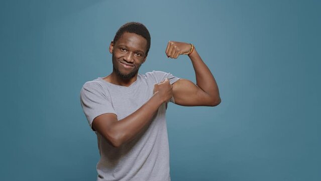 Athletic person flexing biceps and triceps muscles on camera, showing muscular fitness and masculinity. Young fit man expressing endurance and bodybuilding technique. Powerful sportsman.
