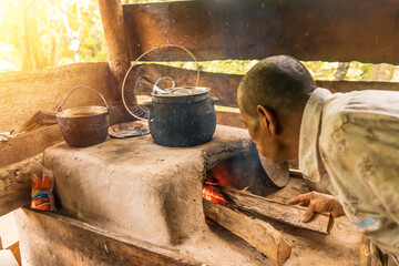 Latino grandfather stoking the fire to cook in his poor house in Nueva Guinea Nicaragua
