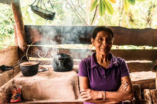 Latin grandmother with crossed arms smiling at camera in the kitchen of her house in Nueva Guinea, Nicaragua