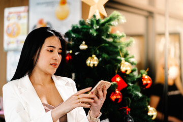 Asian young woman using app on a mobile phone to communicate with friends in cafe. Lifestyle and Technology