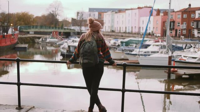 woman in Bristol looking at docked boats in the port.