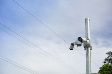 CCTV camera mounted on metal pole with clear sky background with copy space. Reference to the...