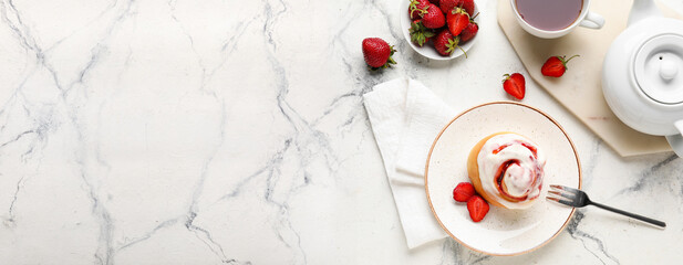 Plate with strawberry cinnamon roll on light background with space for text