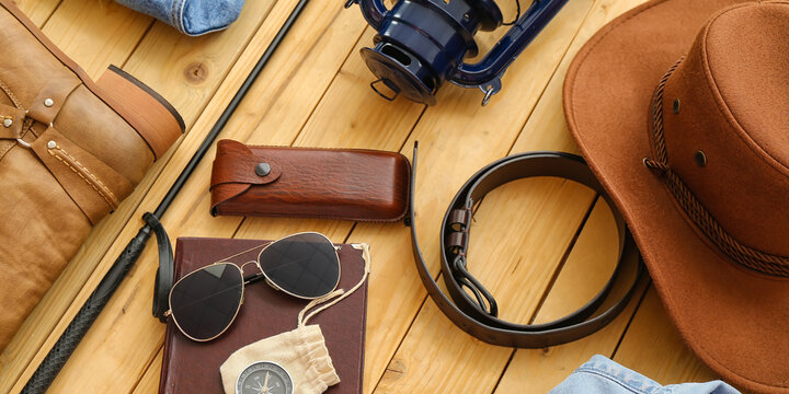 Male accessories for travelling on wooden background